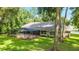 A relaxing screened-in patio extends across the back of this charming home surrounded by a verdant lawn and mature trees at 733 Se 67Th Ln, Ocala, FL 34480