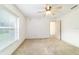 Well-lit bedroom with large window, fan, carpeted floor, and neutral paint, awaiting personal touches at 733 Se 67Th Ln, Ocala, FL 34480