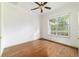 Cozy bedroom featuring wood floors, a large window, and a ceiling fan, offering comfort and style at 733 Se 67Th Ln, Ocala, FL 34480