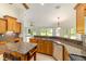 Well-lit kitchen with granite countertops, wooden cabinets, island, and stainless steel appliances at 733 Se 67Th Ln, Ocala, FL 34480