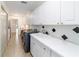 Bright laundry room with ample cabinets, countertop with sink, and modern washer/dryer at 733 Se 67Th Ln, Ocala, FL 34480
