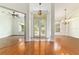 Elegant living room featuring gleaming hardwood floors, white walls, and a chandelier near the entry at 733 Se 67Th Ln, Ocala, FL 34480