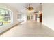 Bright living room with tiled floor, windows to backyard and a screened patio beyond at 733 Se 67Th Ln, Ocala, FL 34480