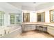Bright bathroom featuring a soaking tub, tile flooring, and vanity with stool at 733 Se 67Th Ln, Ocala, FL 34480
