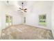 Spacious main bedroom with neutral carpet, ceiling fan, and access to outdoor patio at 733 Se 67Th Ln, Ocala, FL 34480