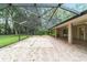 Open screened lanai showcasing brick pavers leading to a spacious backyard and lush greenery at 733 Se 67Th Ln, Ocala, FL 34480