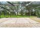 The spacious, screened patio has brick pavers and a tranquil view of the expansive, green backyard at 733 Se 67Th Ln, Ocala, FL 34480