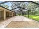 Extensive screened lanai featuring brick pavers and a peaceful view of the lush greenery and lawn at 733 Se 67Th Ln, Ocala, FL 34480
