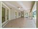 Spacious tiled screened patio with neutral paint, featuring multiple ceiling fans and backyard access doors at 733 Se 67Th Ln, Ocala, FL 34480