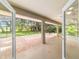 Bright view through doors to a long screened patio featuring a wide open floor plan and access to backyard at 733 Se 67Th Ln, Ocala, FL 34480