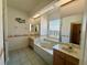 Luxurious bathroom featuring dual sinks, a large soaking tub, and plenty of natural light at 7421 Sw 110Th Pl, Ocala, FL 34476