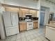 Well-lit kitchen featuring light cabinets, an electric range, and a refrigerator with a bottom freezer at 7421 Sw 110Th Pl, Ocala, FL 34476