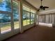 Enclosed patio with large windows offering views of the landscaped backyard and mature trees at 7421 Sw 110Th Pl, Ocala, FL 34476