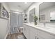 Bright bathroom featuring double sinks and a shower with a striped curtain at 77 Locust Dr, Ocala, FL 34472