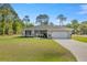 Single-story home boasts a manicured front lawn, a long driveway, and an attached two-car garage at 77 Locust Dr, Ocala, FL 34472
