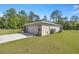 Charming home exterior featuring a wide driveway, two-car garage and well-manicured lawn at 77 Locust Dr, Ocala, FL 34472