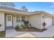 Charming home featuring a well-manicured lawn, fresh landscaping, and a neatly painted garage and entryway at 77 Locust Dr, Ocala, FL 34472