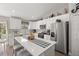 Bright kitchen features white cabinets, stainless steel appliances, and an island with seating at 77 Locust Dr, Ocala, FL 34472