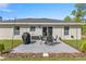 Inviting outdoor patio with dining set, grill, string lights and well-maintained landscaping at 77 Locust Dr, Ocala, FL 34472