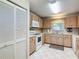 Well-lit kitchen featuring wood cabinets, white appliances, and tile flooring at 8351 Sw 93Rd Ln # D, Ocala, FL 34481