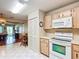 Kitchen featuring wood cabinets, white appliances, and access to dining area at 8351 Sw 93Rd Ln # D, Ocala, FL 34481