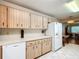 Open kitchen layout with wood cabinets, white appliances, and laminate flooring at 8351 Sw 93Rd Ln # D, Ocala, FL 34481