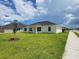 A well-maintained backyard with lush green lawn and a covered patio that provides shade and a comfortable outdoor living space at 8482 Sw 59Th Ter, Ocala, FL 34476