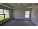 This bedroom offers plush gray carpet, tray ceilings, and large windows, creating a bright and airy space at 8482 Sw 59Th Ter, Ocala, FL 34476