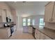 Bright kitchen featuring granite counters, white cabinets, stainless appliances, and tile floors at 8483 Sw 59Th Ter, Ocala, FL 34476