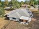 An aerial view of a home with a large roof, screened in porch, and a well maintained lawn at 8990 Se 155Th Pl, Summerfield, FL 34491