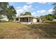 The backyard features a screened-in porch, with a neutral exterior and well-maintained lawn at 8990 Se 155Th Pl, Summerfield, FL 34491