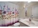 Bathroom featuring a floral shower curtain, toilet, mirror and modern sink at 8990 Se 155Th Pl, Summerfield, FL 34491