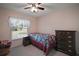 This cozy bedroom features natural light, carpet, and ceiling fan at 8990 Se 155Th Pl, Summerfield, FL 34491