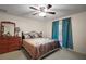 Cozy bedroom with a ceiling fan, large window, and light colored carpet at 8990 Se 155Th Pl, Summerfield, FL 34491