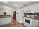 Updated kitchen with white appliances, granite countertops, mosaic backsplash, and sleek wood flooring for a modern look at 8990 Se 155Th Pl, Summerfield, FL 34491