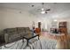 Open-concept living room with neutral walls, hardwood floors, ceiling fan, and ample natural light from large windows at 8990 Se 155Th Pl, Summerfield, FL 34491