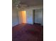 Bedroom featuring ceiling fan, carpet, closet and door leading to other parts of the house at 9012 Sw 91St Cir, Ocala, FL 34481