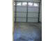 View of the garage door, with concrete floor, ready for parking and storage at 9012 Sw 91St Cir, Ocala, FL 34481