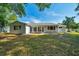 View of the home's backyard featuring lush green grass and a screened-in patio at 9058 Sw 108Th Pl, Ocala, FL 34481