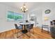 Bright dining area featuring hardwood floors, a modern chandelier, and easy access to the updated kitchen at 9058 Sw 108Th Pl, Ocala, FL 34481