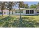 Backyard view of the house featuring a screened lanai and mature trees at 9088 Sw 95Th Ave, Ocala, FL 34481