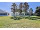 Lawn view of backyard of house with large windows and tree lined border at 9088 Sw 95Th Ave, Ocala, FL 34481