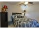 Comfortable bedroom featuring a ceiling fan, plush bedding, and ample lighting at 9088 Sw 95Th Ave, Ocala, FL 34481