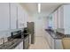 Efficient galley kitchen with white cabinets, stainless steel appliances, and granite countertops at 9088 Sw 95Th Ave, Ocala, FL 34481