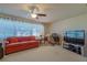 Bright living room featuring neutral carpet, a ceiling fan, and ample natural light at 9088 Sw 95Th Ave, Ocala, FL 34481