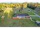 Aerial view of a sprawling brick home with a front yard, surrounding by nature at 9900 Ne 20 Terrace Rd, Anthony, FL 32617