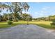 A basketball court resides in the yard of this property with a large shade tree at 9900 Ne 20 Terrace Rd, Anthony, FL 32617