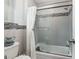 Bathroom showcasing tiled walls and a glass-enclosed shower over a tub at 9900 Ne 20 Terrace Rd, Anthony, FL 32617