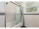 Bathroom featuring tile wall surround, shower over tub and a window at 9900 Ne 20 Terrace Rd, Anthony, FL 32617