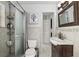 A bathroom features a glass door shower, a standard toilet, and a dark wood vanity at 9900 Ne 20 Terrace Rd, Anthony, FL 32617